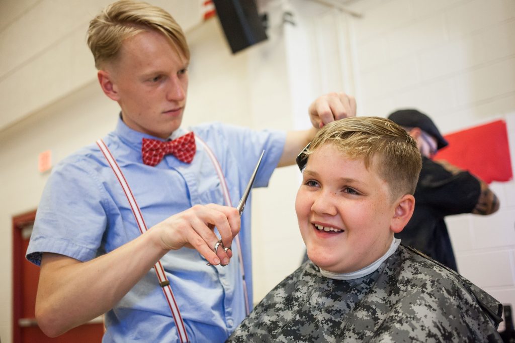 Henry Roberge, 9, of Concord receives a free haircut from New England School of Barbering student Jed Calhoun during the Ready to Learn Fair at Rundlett Middle School in Concord on Wednesday, Aug. 24, 2016. Roberge starts fifth grade at Beaver Meadow School next week. (ELIZABETH FRANTZ / Monitor staff) Elizabeth Frantz