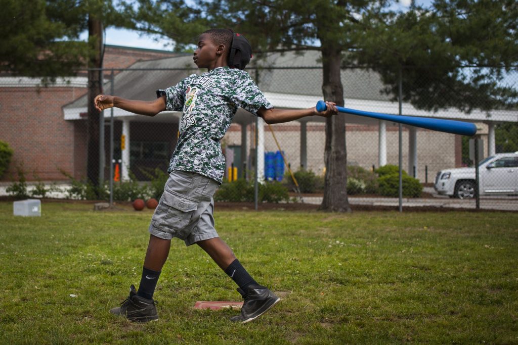 Ten-year-old Japhet Nduwayo of Concord begins to lose his hat after swinging at a wiffle ball during the afterschool program of the Boys and Girls Clubs of Central New Hampshire in Concord on Wednesday, June 15, 2016. (ELIZABETH FRANTZ / Monitor staff) Elizabeth Frantz