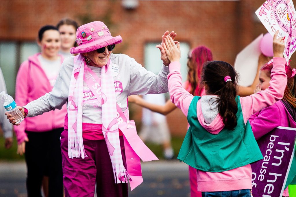 Marnie Verville, 85, of Concord, high-fives Concord girl scout Abby Shagena, 10, near the finish line at Memorial Field. Verville has been a breast cancer survivor for two years, but has been walking annually for six years. Over 5,000 participants walked 2.5 and 5-mile routes starting at Memorial Field during Making Strides Against Breast Cancer in Concord on Sunday, October 20, 2013. The event raised $588,567 for the American Cancer Society, according to publicity co-director Kimberly Laro.  (WILL PARSON / Monitor staff) Will Parson