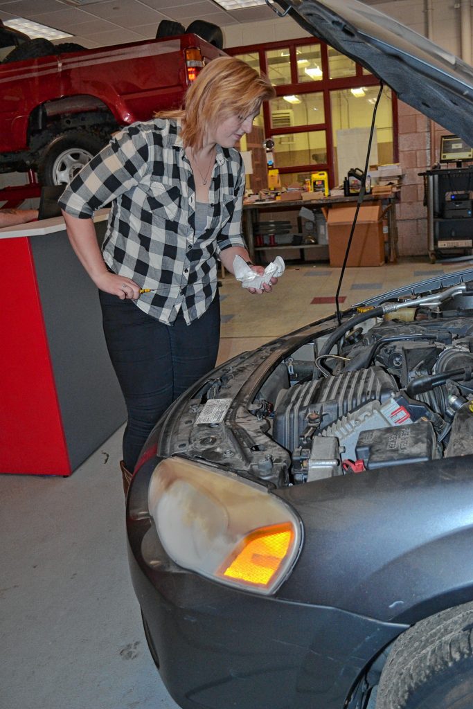 Abigail McIntosh shows us how to check the oil level in an automobile last week. TIM GOODWIN / Insider staff