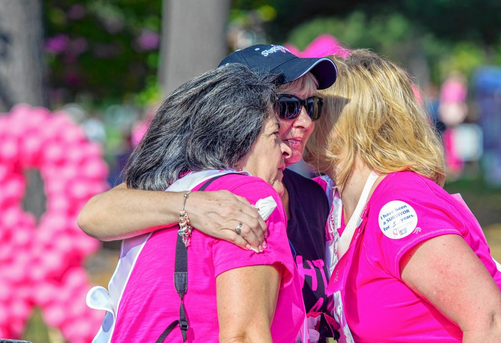 Dayle Wollert (center) gets a double hug from fellow cancer survivors Pauline Steinmetz (left) and Patty Labrie at the Survivor’s tent at the Makings Strides Against Breast Cancer event at Memorial field on Sunday October 15, 2017. GEOFF FORESTER