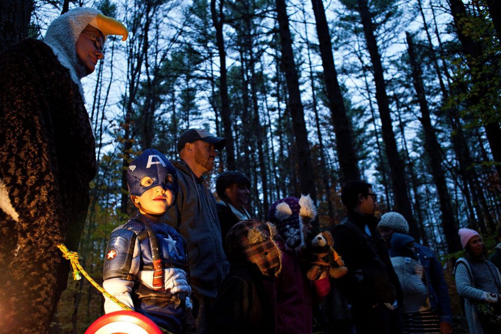 Dressed as Captain America, Indi Santana, 5, of New Market, listens to a skit by volunteers Beth McGuinn, of Canterbury, and Karen Shields, of Concord, during the New Hampshire Audubon’s Enchanted Forest on Saturday evening, October 26, 2013. The Enchanted Forest returned on Saturday after a hiatus since 2004 and offers an educational alternative to haunted houses and haunted forests. The forest had several stops where skits were performed by volunteers and Audubon staff and the trail was lit by jack-o-lanterns.  (JOHN TULLY / Monitor Staff) John Tully