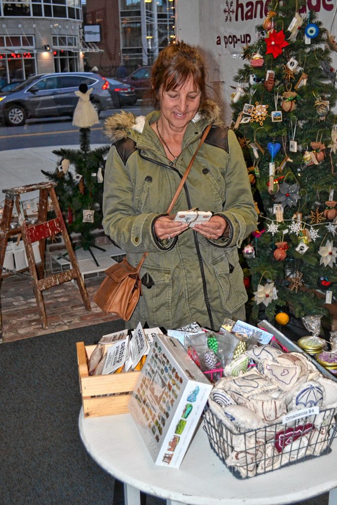 Deede Laplante shops at Concord Handmade during the holiday pop-up shops opening day last week. TIM GOODWIN / Insider staff
