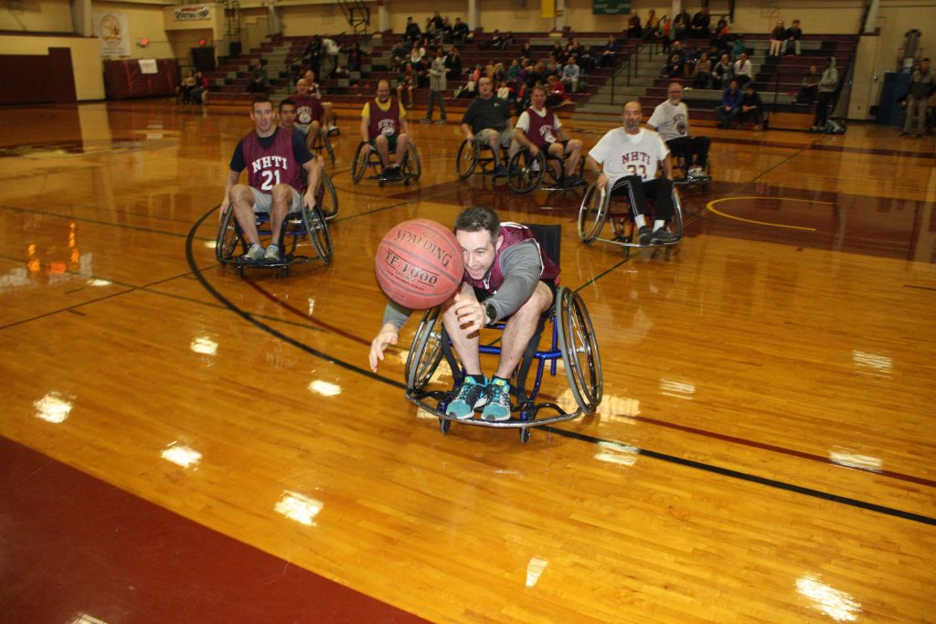 Tom Warner of the NHTI admissions department wheels toward a loose ball during the Wheelchair Basketball Benefit at NHTI last week. (JON BODELL / Insider staff) JON BODELL / Insider staff
