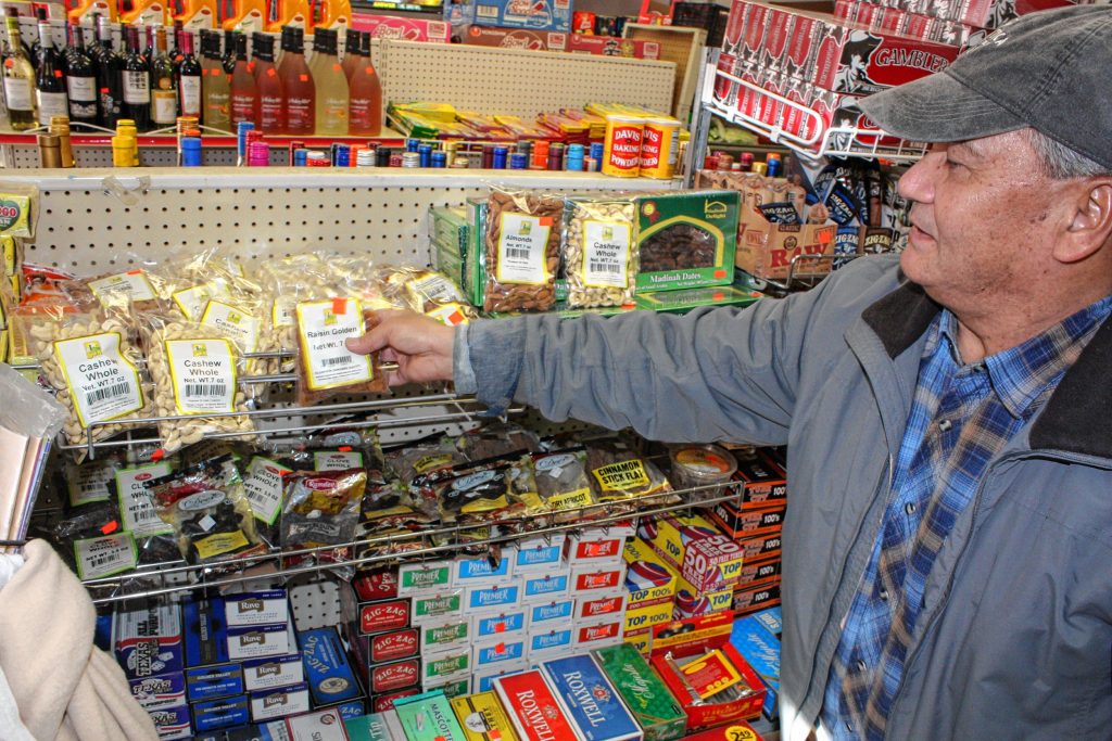 Dhruba Shrestha, owner of the international grocery store Concord Mart on North Main Street, points out some of the items at his store that are more popular among American customers -- nuts, raisins,  dates and cloves, mostly. JON BODELL / Insider staff