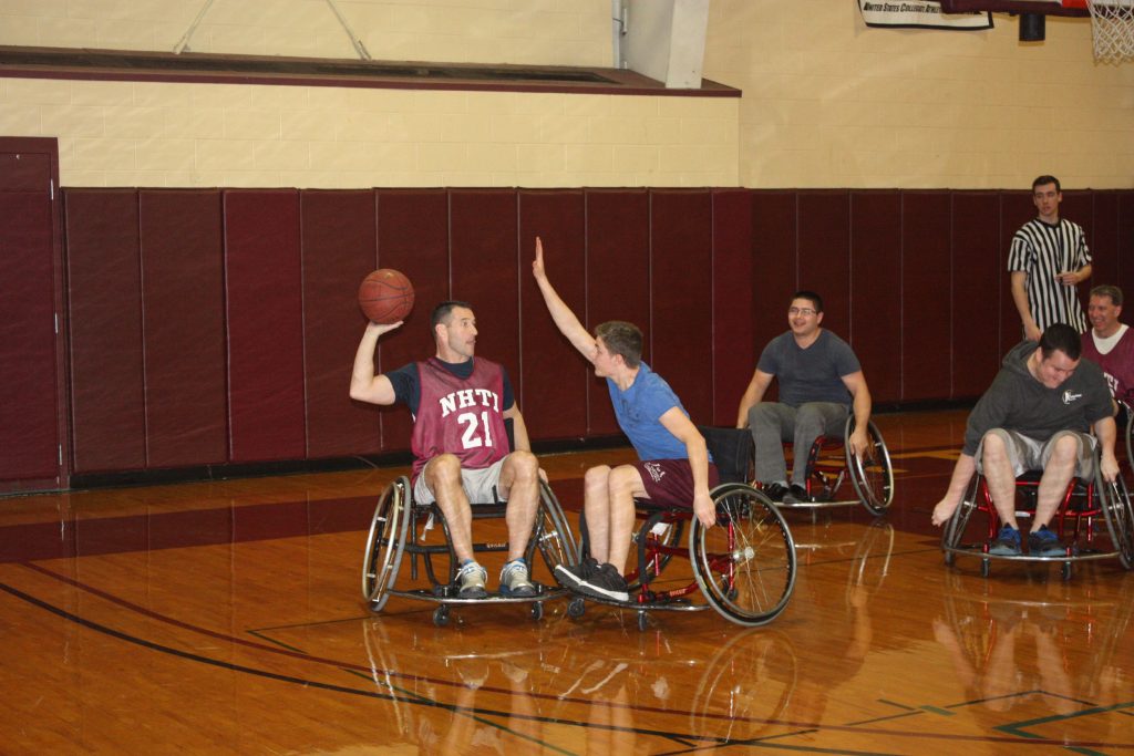 NHTI faculty member Chuck Lloyd looks for someone to pass to while a student plays tight defense during the Wheelchair Basketball Benefit at NHTI last week. (JON BODELL / Insider staff) JON BODELL / Insider staff