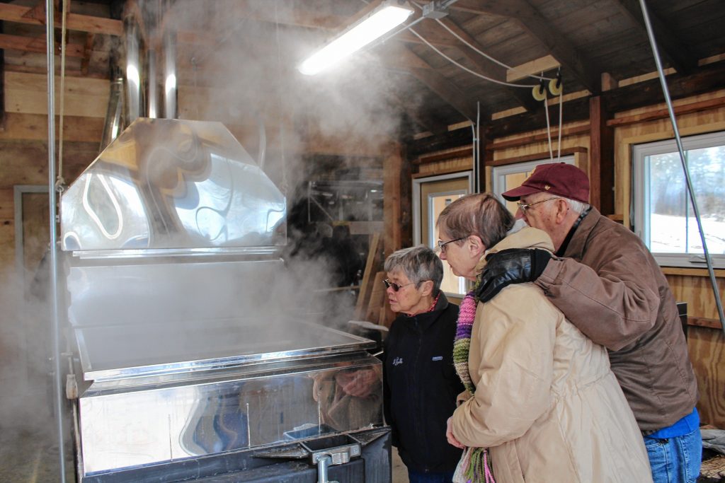 Linda Lynch, and Leo and Gloria Van Beaver watch sap collected at Havenwood boiled into syrup at Mapletree Farm. Courtesy