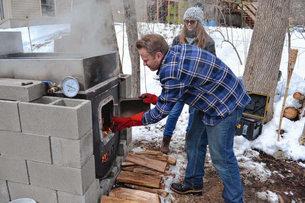 Andrew Mattiace tends to the fire while boiling his fourth batch of maple syrup on Saturday, while his girlfriend Wendy Zona looks on. TIM GOODWIN / Insider staff