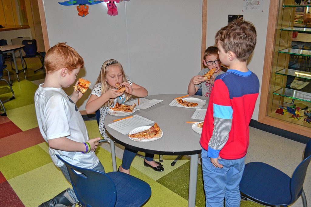 Will Bailey, Lilla Marston, Logan Sullivan and Colin  Smith enjoy a few slices of pizza during a blind taste-test at Christa McAuliffe School last week. TIM GOODWIN / Insider staff
