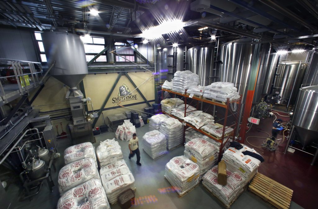 This Thursday, Nov. 16, 2017 photo shows energy efficient motion activated LED lights, along with window light, that illuminate the Smuttynose Brewery in Hampton, N.H. The brewhouse is taking advantage of special programs to use new technology to reduce its carbon footprint. (AP Photo/Robert F. Bukaty)  Robert F. Bukaty