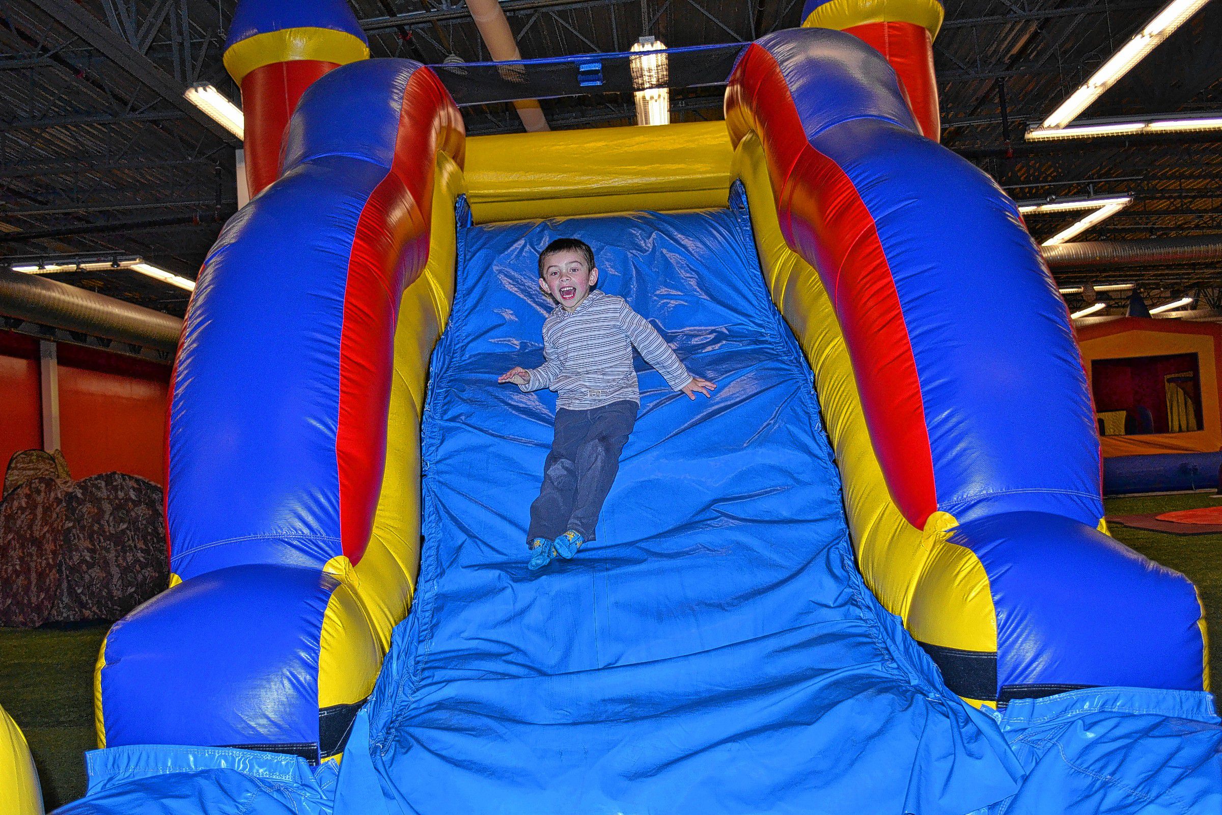 Chris Smykil belly-flops onto Jon White in the Sumo wrestling ring inside Bounce House Entertainment Center. Good thing they were wearing those suits! Below: Braden Bosco, 5, has a whale of a time. 