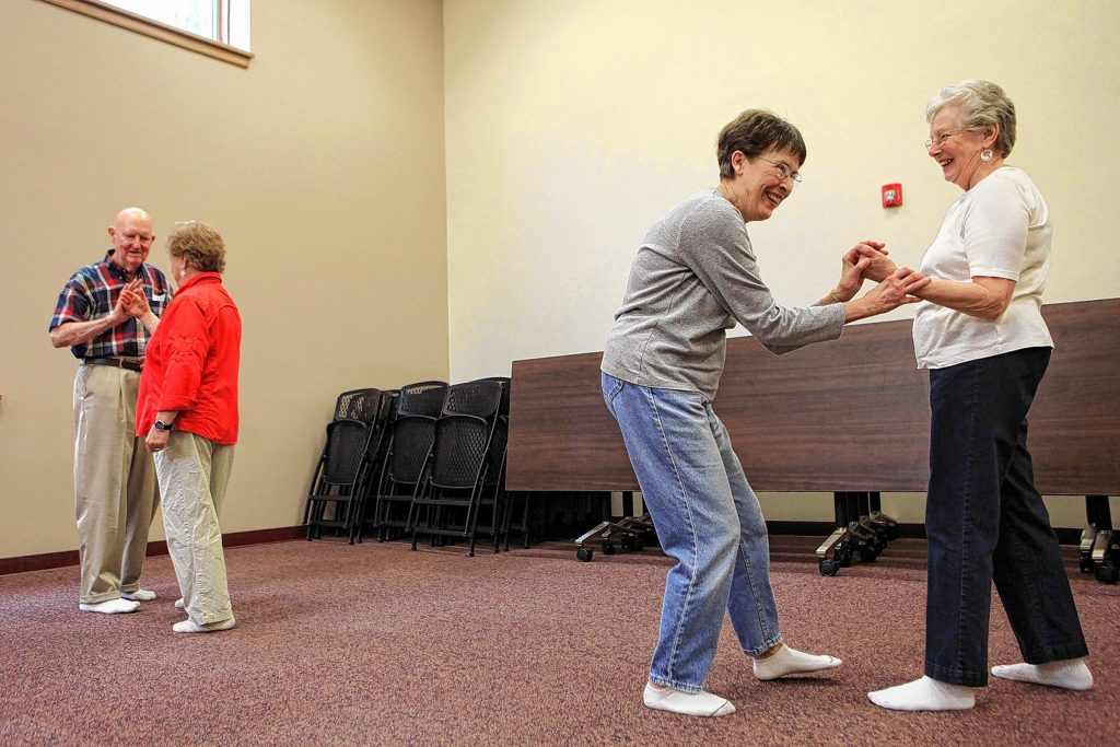 Pat Miniutt (right) and her sister-in-law Nancy Miniutti laugh as they try reposition themselves while they were working on a push hands training routine during a tai chi class on April 15, 2014. The Centennial Center was being renamed Good Life Programs and has expanded its membership from about 60 to almost 1,000 in a year. (ARIANA van den AKKER / Monitor staff) 