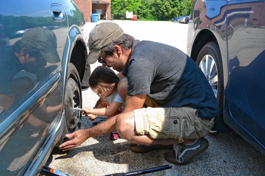 Jon got a puncture in his rear left tire on his way to work last week so he called in his daughter, Julia, to help change it. TIM GOODWIN / Insider staff
