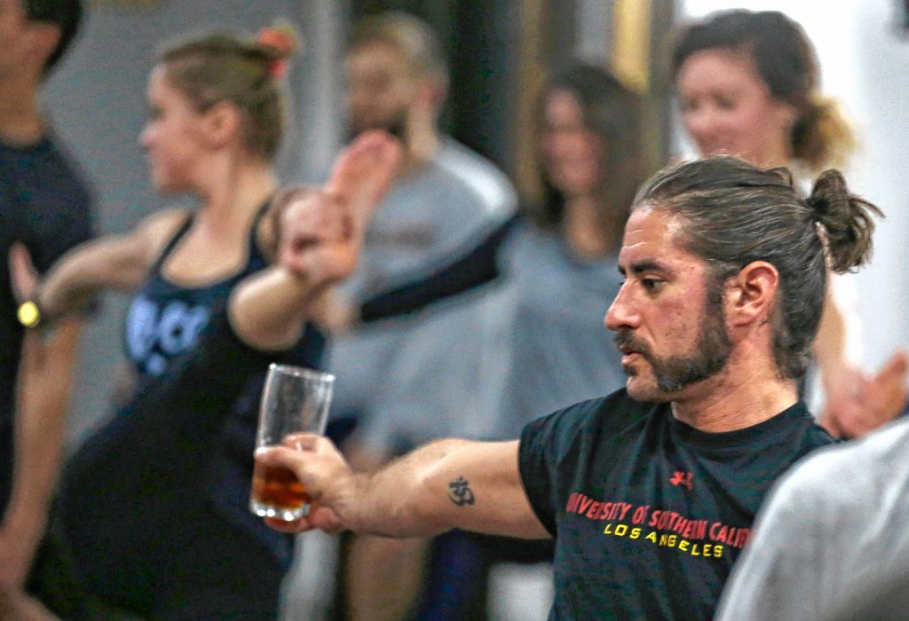 In this Thursday, Dec. 3, 2015 photo, Reed Patterson practices yoga while holding onto his beer at the Platform Beer Co., in Cleveland. Craft breweries are partnering up with yoga studios around the country as more breweries are hosting classes to attract a new crowd to the bars and yoga studios are using the beer to get more men to try yoga. (AP Photo/Tony Dejak) Tony Dejak