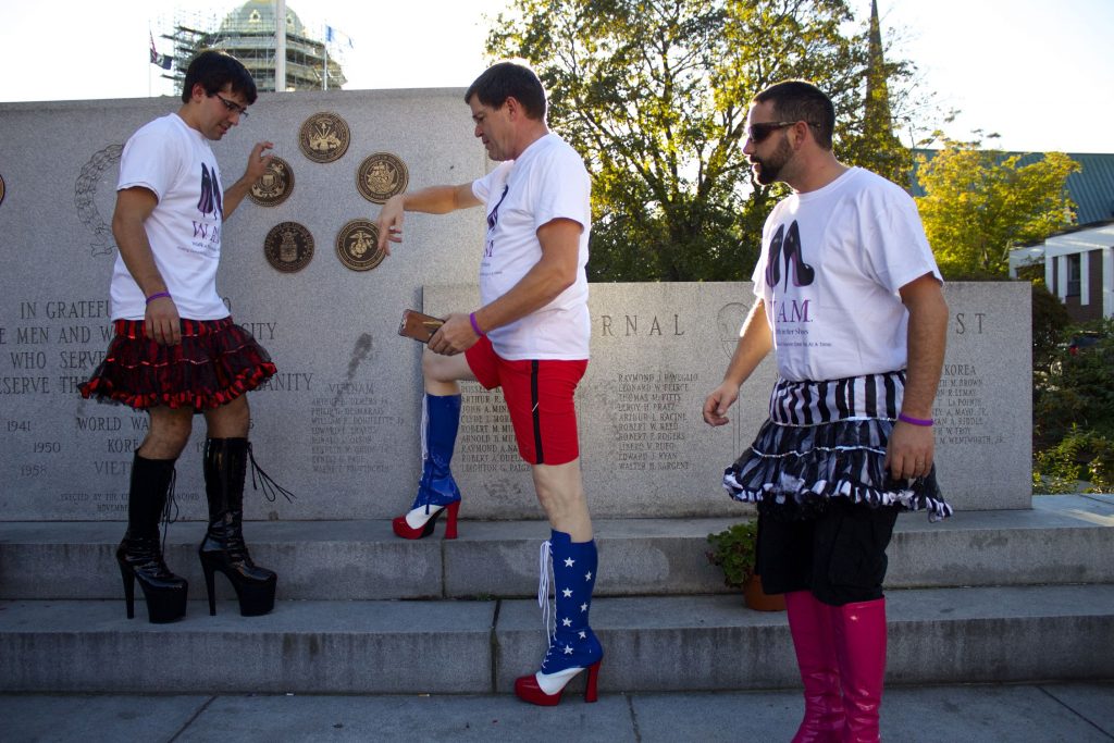 Adam Memmolo, right, Marc Racine, center, and Bob McCullen, left, all with the Grappone team for Walk A Mile In Her Shoes, arrange themselves for a cell phone photo on Wednesday, Oct. 5, 2016.  
