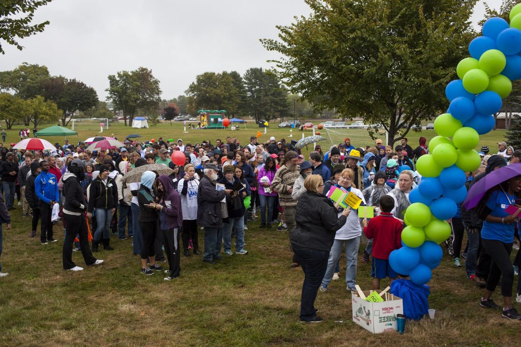 Walkers pick up signs and pass through a balloon arch at the start of NAMIWalks NH on Sunday in Concord, Oct. 2, 2016. (ELIZABETH FRANTZ / Monitor staff) ELIZABETH FRANTZ