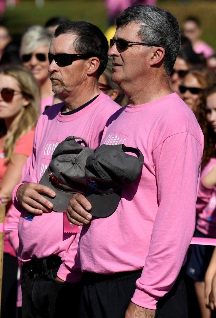 Brothers Steve and Ed Murphy stand for the national anthem during the opening ceremonies of the 2017 Making Strides Against Breast Cancer Walk at Memorial Field in Concord.  Courtesy of Kathi Russ