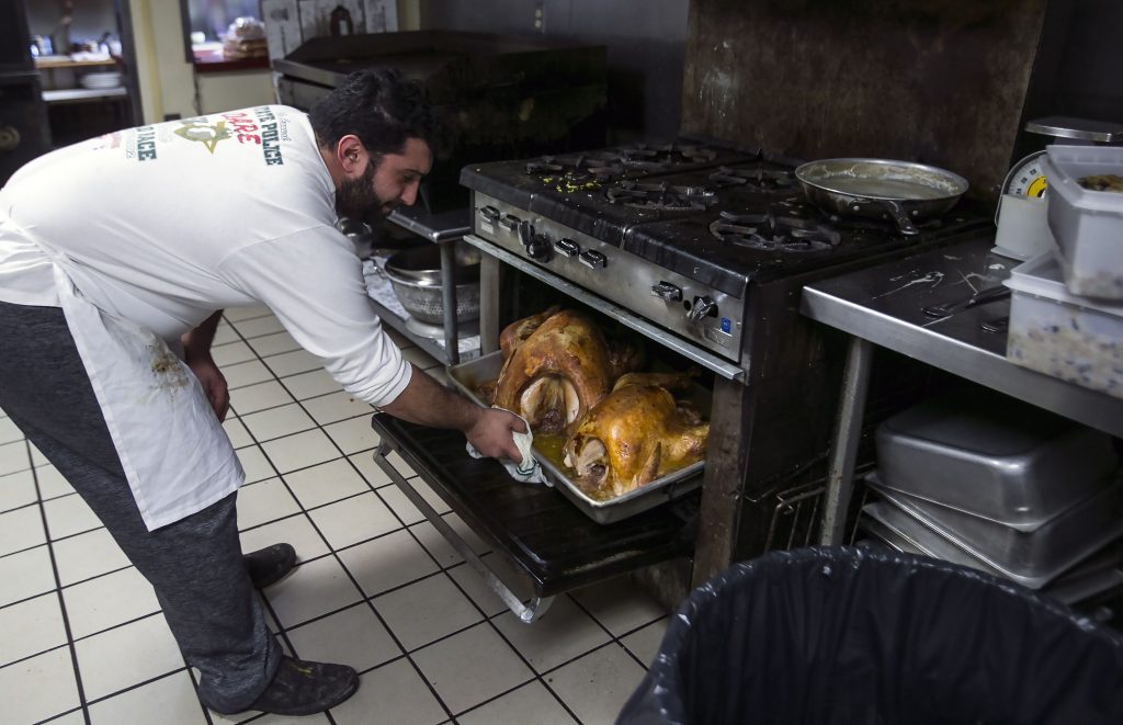 Kosmas Smirniousdis checks on two of the 65 turkeys the Windmill Family Restaurant is cooking in preparation for the Thanksgiving dinners the restaurant is offering Thursday from noon to three. Smirnioudis’ father started the tradition in 1990 when he paired with the Friendly Kitchen in offering the dinners. GEOFF FORESTER