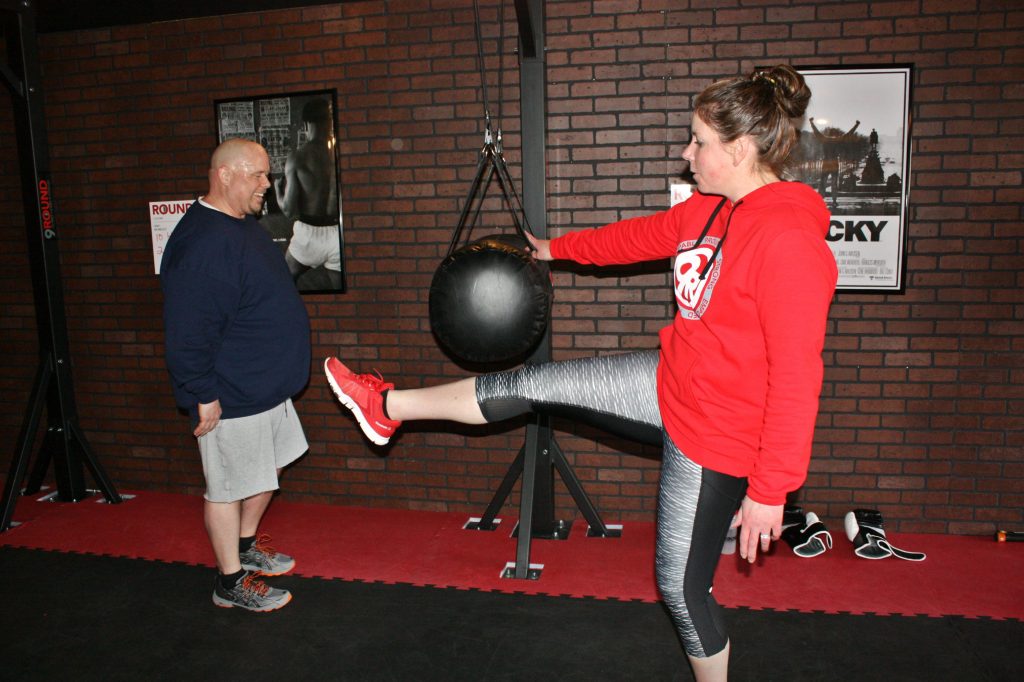 9Round owner Laurie Weingartner works with Les Reed on a kicking workout at 9Round, the new kickboxing-style gym on Ford Eddy Road, last week. JON BODELL / Insider staff