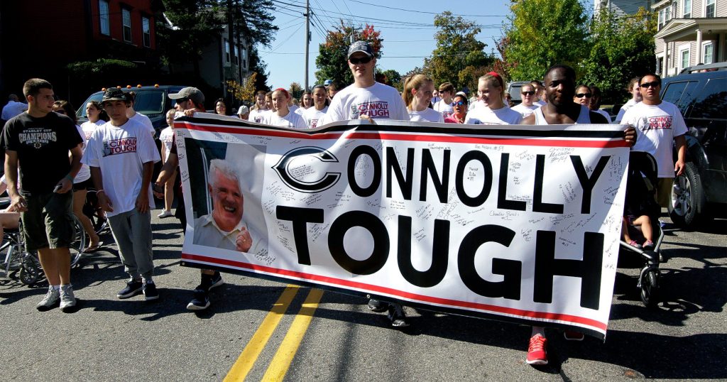 Participants in the ALS walk parade down Pleasant Street Saturday morning in support of Concord High School Principal Gene Connolly.  (GEOFF FORESTER / Monitor staff) Participants hold a “Connolly Tough” banner as they march down Pleasant Street.(GEOFF FORESTER / Monitor staff)     GEOFF FORESTER