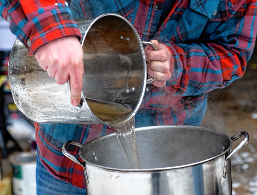 Andrew Mattiace pours out some sap for his syruping operation at his Bow home on Saturday, March 2, 2019. GEOFF FORESTER