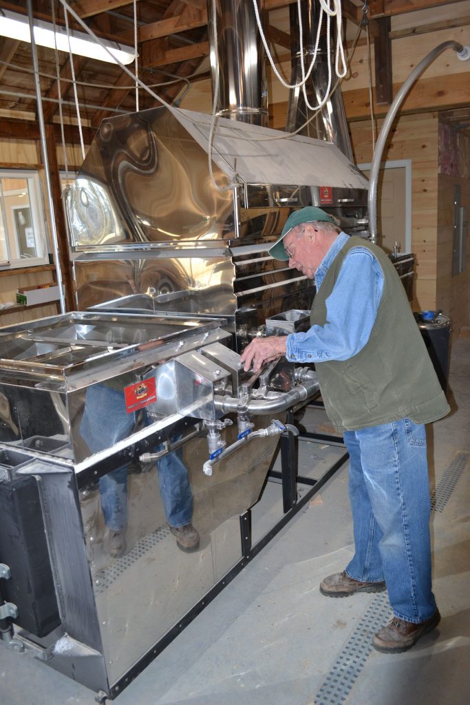 Mapletree Farm owner Dean Wilber installs a thermometer in the new evaporator that is the star of the show in his newly expanded sugarhouse. TIM GOODWIN / Insider staff
