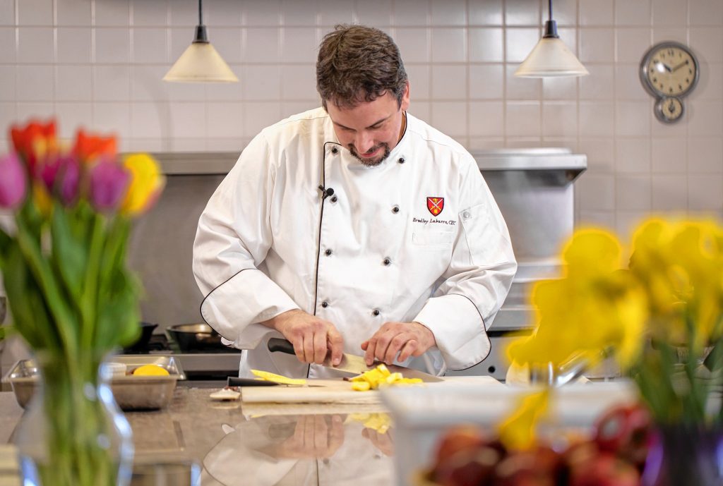 Bradley Labarre, rectory chef at St. Paul's School, demonstrates some of his skills on the job recently. Labarre will compete against two other Granite State chefs in the New Hampshire Food Bank Steel Chef Challenge in Manchester on March 11.  Courtesy of Derek Thomson