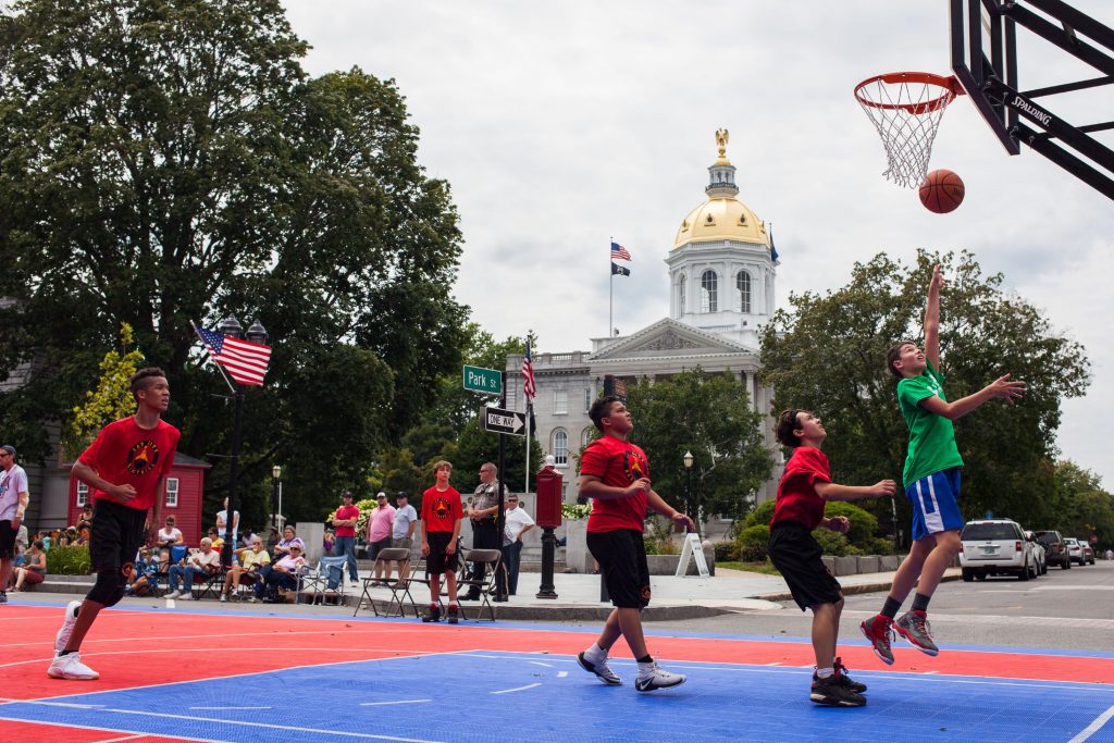 Nashua Sports Academy C4 team member Trevor Labrecque (right), 12, shoots a layup during a 3-on-3 boys basketball tournament game against the Cap City Basketball Spurs team during Rock On Fest in downtown Concord on Friday, Aug. 11, 2017. (ELIZABETH FRANTZ / Monitor staff) ELIZABETH FRANTZ
