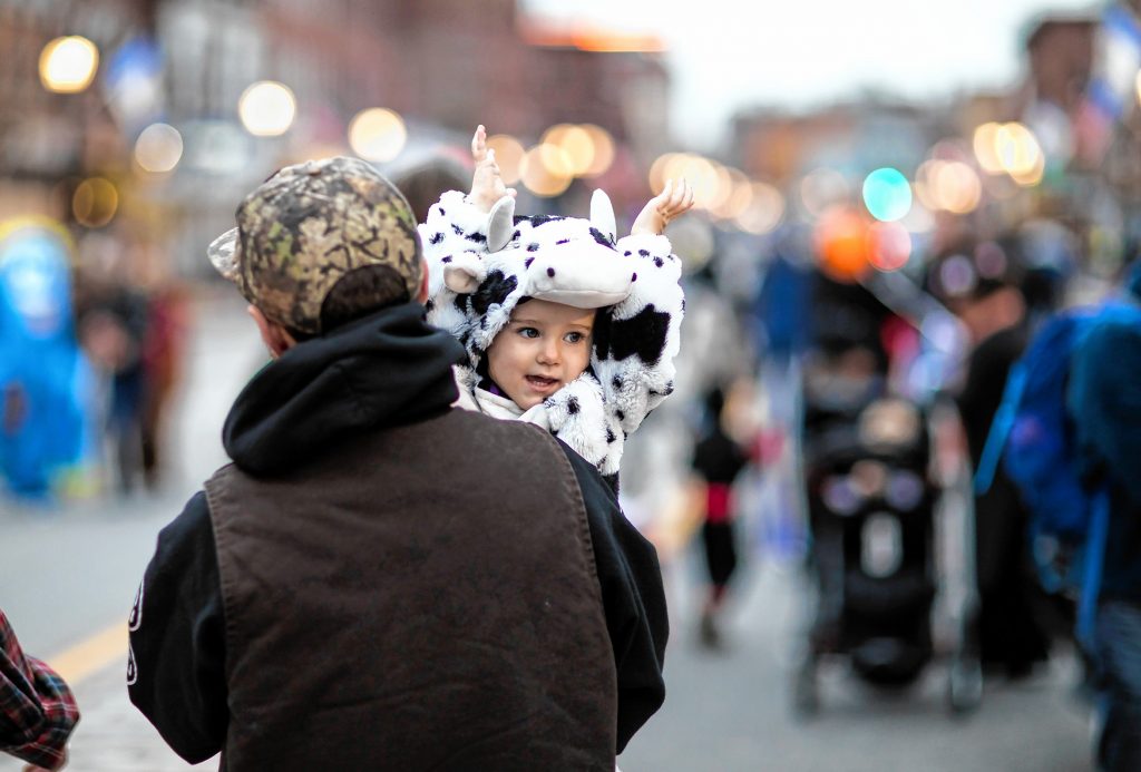 Lumin Perron, 2, in her cow costume walks down Main Street in Concord with her dad Taylor during the Halloween Howl on Friday evening, October 25, 2019. GEOFF FORESTER