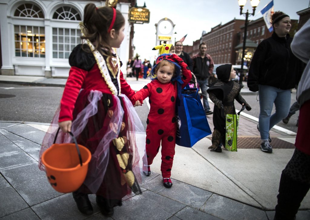 Morgan Hallee, 5, (left) and her cousin Aubree Cate, 3, of Manchester make their way down Main Street at the Halloween Howl on Friday evening, October 25, 2019. GEOFF FORESTER