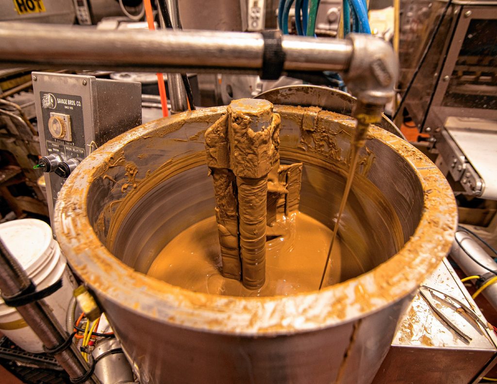 A vat of milk chocolate being mixed up at the Granite State Candy store on Warren Street in Concord on Thursday, December 12, 2019. GEOFF FORESTER