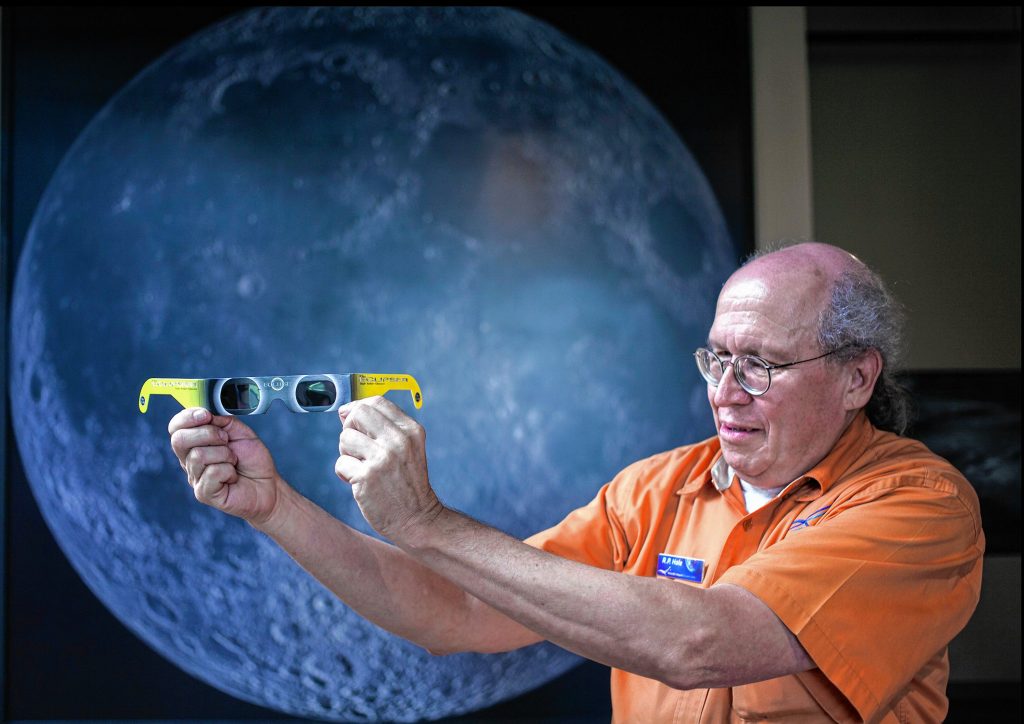McAuliffe-Shepard Discovery Center senior educator R. P. Hale holds up the correct glasses the center has for the public to observe the partial eclipse on August 21, 2017. 