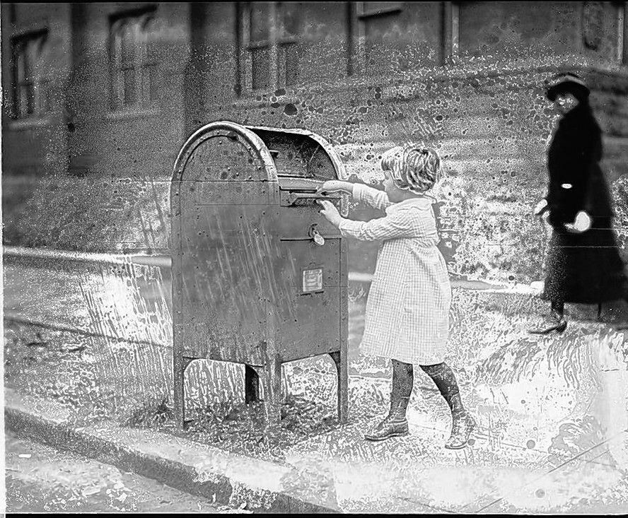 A young girl mails a letter.  