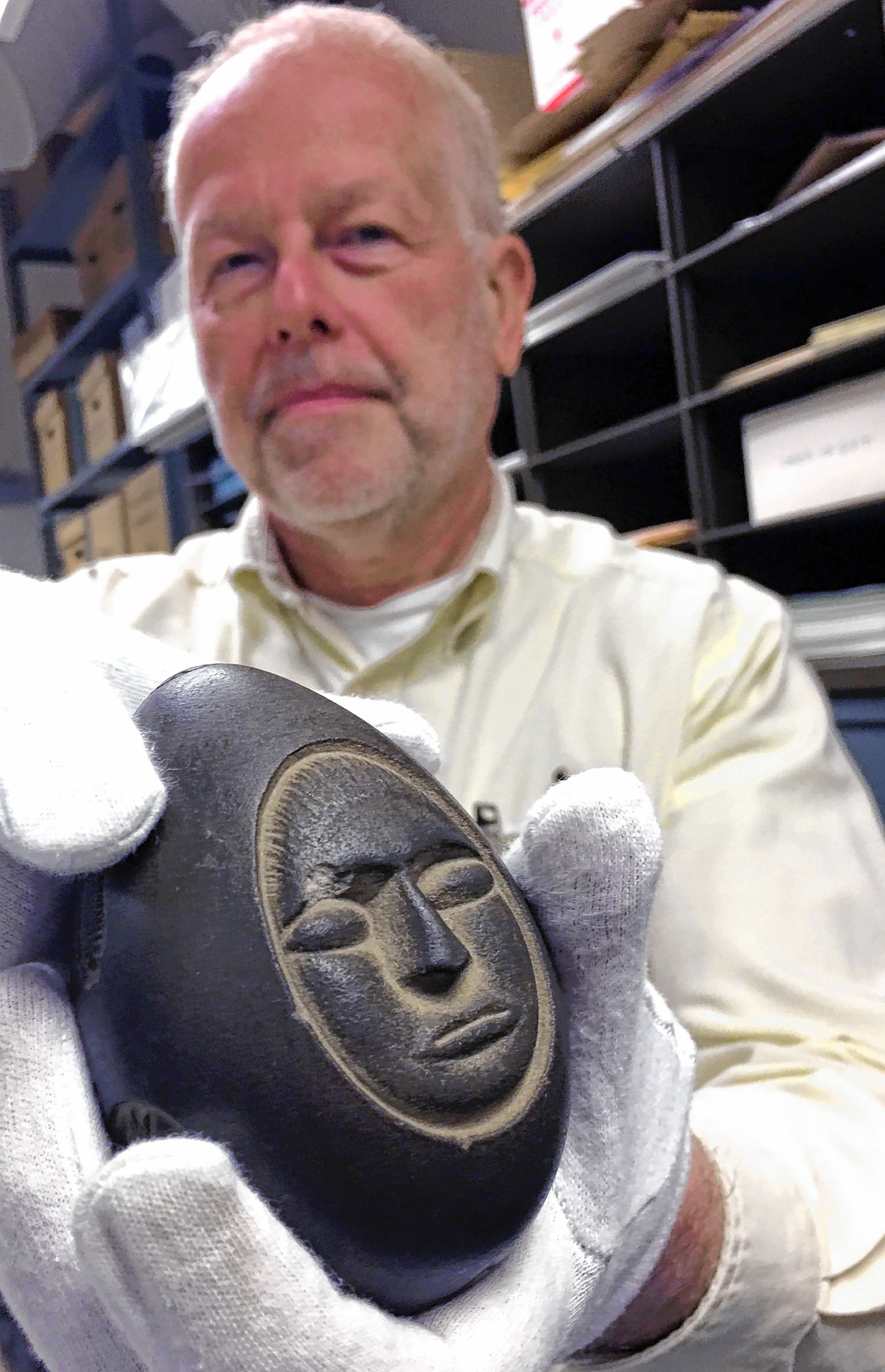 Wesley Balla, director of collections and exhibitions for the New Hampshire Historical Society, holds the mystery stone at the societyâs collections headquarters on Storrs Street in Concord Wednesday. 
