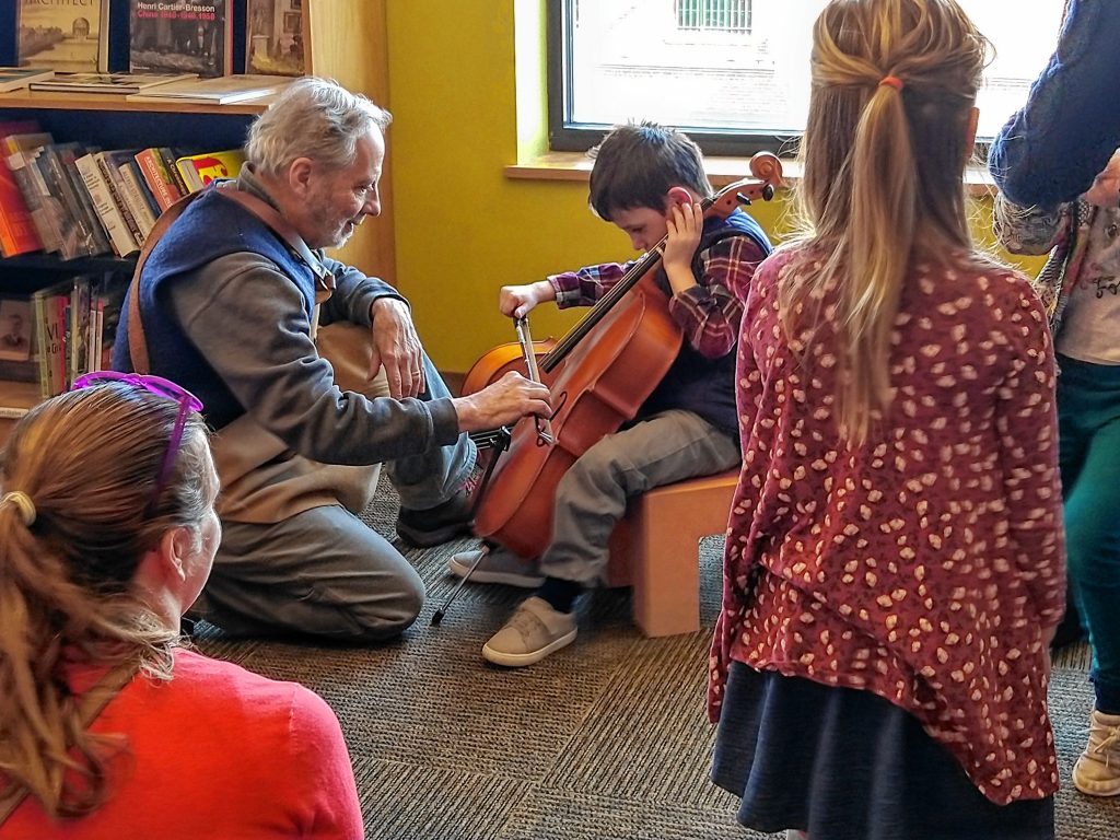 Myles Speck learns about the cello from luthier Paul Perley.  