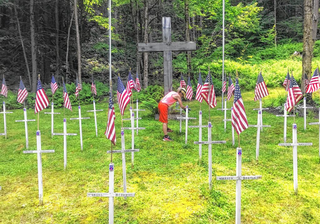Michele Bartlett paints crosses at a memorial for the 10th Mountain Division that was started by her father-in-law.  