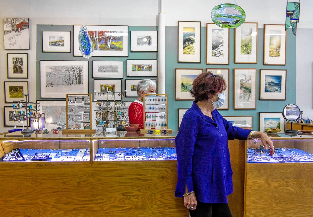 Employees Penny Verville (left) and Su Egan (right) talking to a customer inside of  the League of NH Craftsman located in Downtown Concord on Main Street October 1st, 2020. ALLIE ST PETER