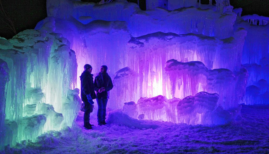 In this Wednesday, Jan. 8, 2014 photo, patrons tour an ice castle at the base of the Loon Mountain ski resort in Lincoln, N.H. The ice castle begins to grow in the fall when the weather gets below freezing and thousands of icicles are made and harvested then placed around sprinkler heads and sprayed with water.  The castle will continue to grow as long as the temperatures stay below freezing. (AP Photo/Jim Cole) Jim Cole