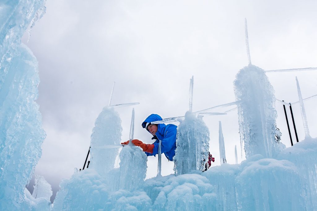 Sherri Covell of Ashland fuses icicles to the top of an in-progress ice tower at Ice Castles in Lincoln on Tuesday, Dec. 19, 2017. (ELIZABETH FRANTZ / Monitor staff) Elizabeth Frantz