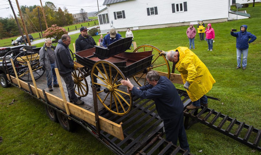 With the help of the Penacook Historical Society, the Abbot-Downing Historical Society was able to store of its eight 19th century coaches and carriages at the Rolfe Barn on Penacook Street on Tuesday, October 27, 2021. The members of the Abbot-Downing Historical Society roll one of the carriages off the flatbed to be put in the barn. GEOFF FORESTER