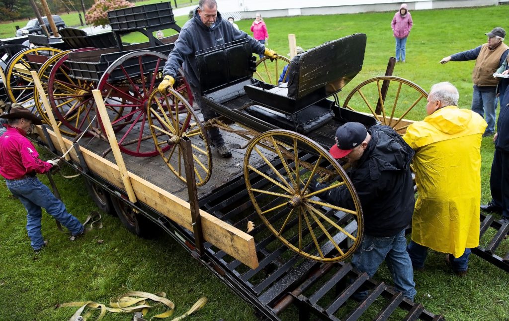 With the help of the Penacook Historical Society, the Abbot-Downing Historical Society was able to store of its eight 19th century coaches and carriages at the Rolfe Barn on Penacook Street on Tuesday, October 27, 2021. The members of the Abbot-Downing Historical Society roll one of the carriages off the flatbed near the barn. GEOFF FORESTER