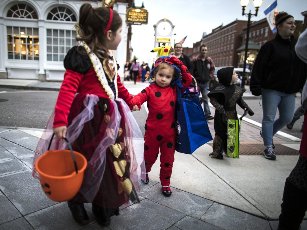 Morgan Hallee, 5, (left) and her cousin Aubree Cate, 3, of Manchester make their way down Main Street at the Halloween Howl on Friday evening, October 25, 2019. GEOFF FORESTER