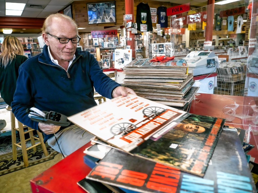 Pitchfork Records owner Michael Cohen sifts through albums to mark prices at the downtown store on Wednesday, November 9, 2022. GEOFF FORESTER