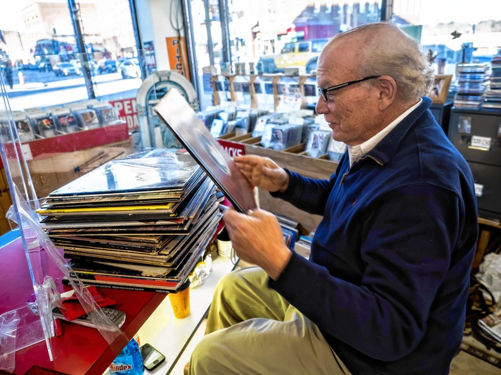 Pitchfork Records owner Michael Cohen sifts through albums to mark for pricing at the downtown store on Wednesday, November 9, 2022. GEOFF FORESTER