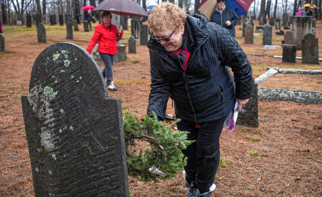Daughter of the American Revolution Regent Kathleen A. Sternenberg of the Buntin-Rumford-Webster Chapter of the NSDAR places a wreath at a marker at the Wreaths Across America ceremony at the Old Fort Cemetery on Shawmut Street in East Concord on Saturday, December 14, 2019. The Buntin-Rumford-Webster Chapter of the Daughters of the American Revolution sponsored the event along with Naval Sea Cadets that placed 28 wreaths on veterans in the cemetery, including 13 from the Revolutionary War. 