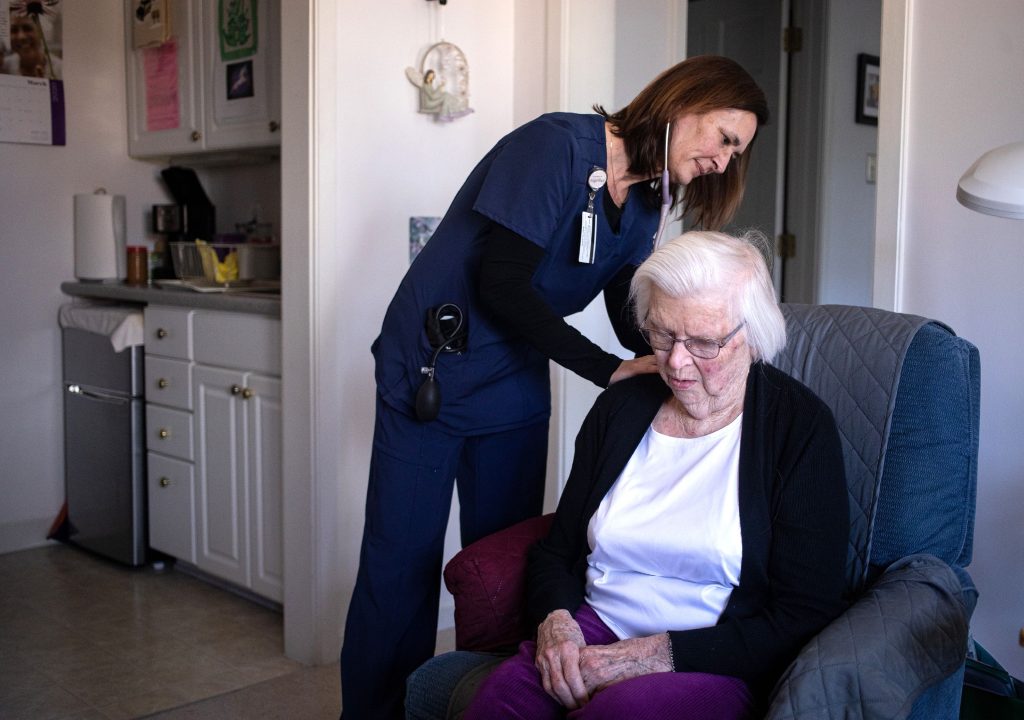 Home care nurse Denise Livingston listens to Earl Raymond's breathing  in her room during her examination at Havenwood Heritage Heights on Thursday, March 5, 2020. GEOFF FORESTER