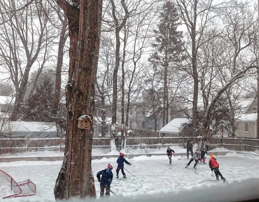 Kids play on the Philbrick's hockey rink during a snowstorm. Oct. 23, 2023. 