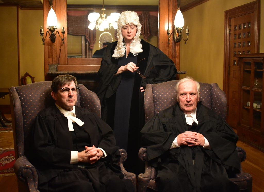 Chris Connell and John Conlon (from left) play sparring barristers for prosecution and defense in Agatha Christie’s “Witness for the Prosecution,” Feb. 16-18 at Concord City Auditorium. Valerie Kehr (standing) casts a jaundiced eye on the proceedings in the role of Justice Wainwright.
